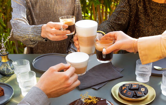 Eine Menschengruppe die verschiedene Nespresso Kaffeesorten trinken.
