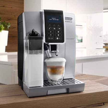 De'Longhi Dinamica auf einer Arbeitsplatte mit einem zubereiteten Kaffee